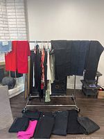 Clothing rack with assorted jeans and pants including red, black, and blue colors.
