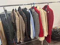 Full view of assorted ladies coats, jackets, and blazers on rack in size small/medium, showing various colors and patterns.