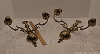 Pair of brass wall sconces photographed on a table with ruler for size reference, showing front and side views.
