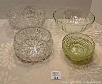 Set of five glass and crystal bowls on patterned cloth, showing variety of sizes and designs
