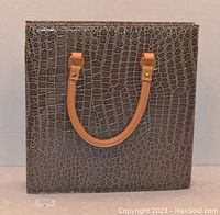 Front view of the square briefcase handbag showing the crocodile pattern and tan handles.