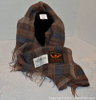 Full view of scarf draped to display texture, color, and labels.