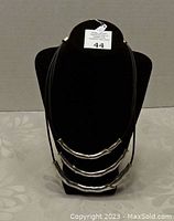 Front view of vintage leather and silver metal necklace displayed on black jewelry bust showing full length and layout.