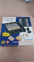 Box of 7 in 1 Combination Game Set showing included games: chess, checkers, backgammon, cribbage, dominoes, dice, playing cards.