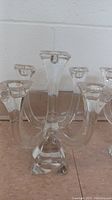 Close-up photo of one vintage crystal candelabra showing five arms and clear crystal build with square base.