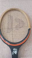Top view of the wooden tennis racket head showing string pattern, Bjorn Borg signature and round shamrock design.