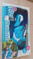 Front view of Fomilator toy foam sprayer in original box showing toy and foam fluid bottle.