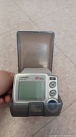 Front view of Omron HEM-637 wrist heart monitor in closed transparent storage case.