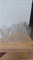 Set of six glass ice cream sundae cups arranged in two rows seen from the front side.