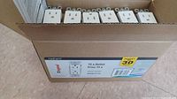 Box of 30 white 15 Amp electrical outlets, showing the box opened with electrical outlets lined inside clearly visible.
