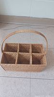Top and slightly angled view showing the basket's six compartments and woven wicker structure.
