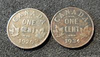 Reverse view of the 1920 and 1934 Canada small one cent coins showing denomination, date, and maple leaf design.