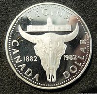 Close-up of the reverse side of the 1982 Canadian silver proof dollar coin showing a buffalo skull with building and inscriptions.