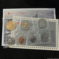 Photo showing front view of sealed 1997 Canadian seven coin uncirculated set with coins visible in clear plastic sleeves and included informational card and envelope.