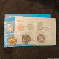 Front view of the 1999 Canada 7 coin uncirculated set sealed in original packaging with informational backing card from Royal Canadian Mint.