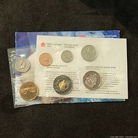 Photo showing sealed 2000 Canadian uncirculated 7 coin set with coins secured in plastic pouch inside mint packaging.