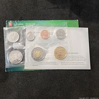 Photo showing the full sealed 7 coin set from the Royal Canadian Mint along with certificate of authenticity and branded display card.