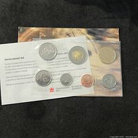 7 Canadian coins from 2001 Royal Canadian Mint uncirculated set displayed in sealed packaging with information leaflet visible.