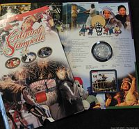 Opened display folder showing the Calgary Stampede booklet and the 2002 silver coin in protective casing.