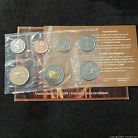 Photo showing front view of all 7 coins sealed in plastic with backing card detailing the uncirculated set from 2004 Canada.