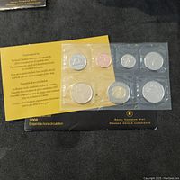 Seven Canadian coins from 2005 in original Royal Canadian Mint yellow sealed packaging with informational insert visible underneath
