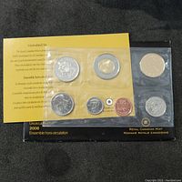 Photo showing front view of the 2008 Canadian uncirculated coin set with 7 coins in mint sealed packaging along with yellow informational insert from Royal Canadian Mint.