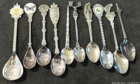 Full view of all 10 spoons laid flat with handle design and bowls visible