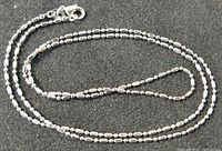 Close-up photo of sterling silver chain showing chain texture and lobster clasp.