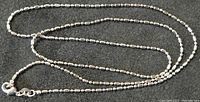 Sterling silver chain necklace laid out showing full length with visible clasp and link pattern.