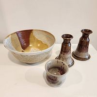 Overall view of the signed bowl and three candle holders showing glaze details and condition.