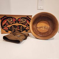 Photo of all three items: wood bowl with circular inlaid scene, rectangular wood box with Indigenous-style art, and brown leather journal cover.