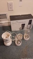 Isagenix Promixx IsaBlender blender base, blending jar with blade attachments, and original box included in the lot, lying on carpeted floor