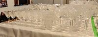 Wide arrangement of various crystal stemware pieces in Queen Anne's Lace pattern showing different sizes and shapes.