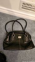 Black leather Danier purse with handles and metal plaque on front