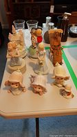 Full view of all figurines including music boxes and hand-carved figure on table showing size and details