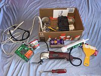 Overview of assorted electric power tool accessories and tools including boxes, tape, cutters, blades, and extension cords.