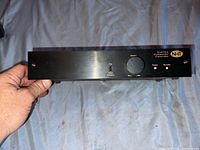 Front view showing volume knob, Flat and Video contour toggles, power and standby lights, and NHT logo on the right side.