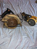 Photo of both Skil Saw Classic 7 1/4 inch circular saw and DeWalt random orbital sander together showing size and condition.