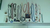 Overview photo showing all bead strings and bags of loose beads arranged side by side with measuring scale beneath