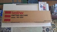 Cardboard shipping/retail box labeled “Brother Knitting Machine Model KH-890” alongside pattern booklet