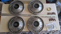 Set of four round metal Chevrolet Chevelle hubcaps with concentric circular design and Chevrolet bowtie emblems in center showing size and condition.