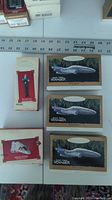 Five boxes of Hallmark Keepsake ornaments arranged on table with ruler, showing scale and condition.