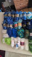 Photo showing multiple skeins of blue, green, white, and mixed novelty and eyelash yarn
