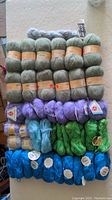 Full lot overview of 40 skeins of yarn in multiple colors arranged on a table.