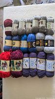 Top view of all 19 skeins of yarn showing various colors and labels