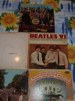 Photo showing 4 of the 5 Beatles albums: Beatles VI, Magical Mystery Tour, Abbey Road, and one white cover album labeled The Beatles