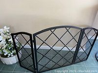 Full view of black metal fireplace screen with one front panel and two side panels, showing the overall design and size.
