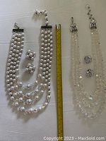 Two large pearl-like crystal necklaces with matching clip-on earrings, length approx. 8 and 9 inches measured with ruler beside them.