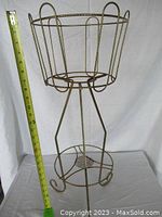 Single image of twisted wire plant stand with measuring tape showing height of approximately 29 inches.