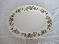 Top view of the oval platter showing the detailed purple thistle floral rim pattern with gold edging on white porcelain.